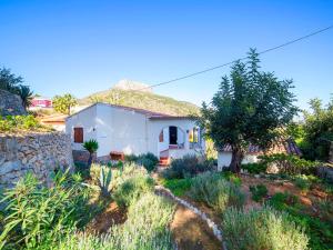 uma pequena casa branca com uma parede de pedra em Holiday Home Silene by Interhome em La Canuta