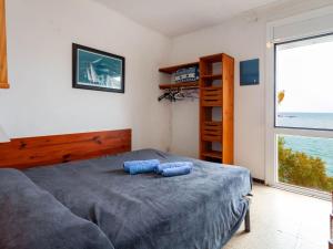 a bedroom with a bed with two blue pillows on it at Holiday Home Villa Cassiopee by Interhome in Llança