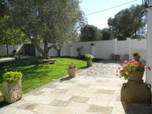 um jardim com vasos de plantas e uma cerca branca em Holiday Home Grande by Interhome em Vignacastrisi
