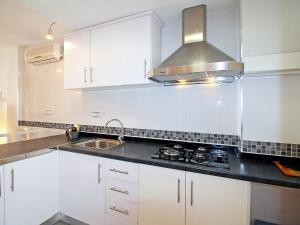 a white kitchen with a sink and a stove at Apartment Sol Y Mar by Interhome in Altea +12 photos