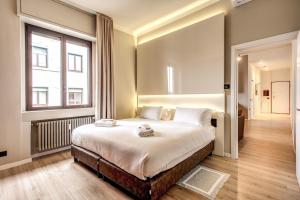 a bedroom with a large bed and a large window at Suite Santa Tecla in Milan