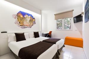 a hotel room with two beds and a tv at Hotel Travessera in Barcelona