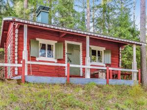 ein rotes winziges Haus im Wald in der Unterkunft Holiday Home Heinälampi by Interhome in Laakkii