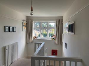 ein weißes Zimmer mit einer Treppe und einem Fenster in der Unterkunft Picaroons Bed and Breakfast in Sheringham