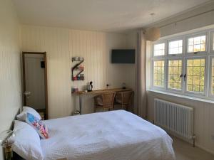 um quarto com uma cama, uma secretária e uma janela em Picaroons Bed and Breakfast em Sheringham