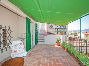 un patio con una sombrilla verde y una silla en el balcón en Apartment La Torretta by Interhome en Florence