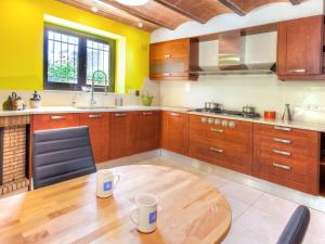 a kitchen with wooden cabinets and a wooden table at Holiday Home La Tilia by Interhome in Calonge