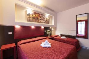 Habitación de hotel con 2 camas con sábanas rojas en Imperial Suite Guest House, en Roma