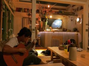 - un homme jouant de la guitare dans le salon dans l'établissement NEMARU Live with Books, à Nagaoka