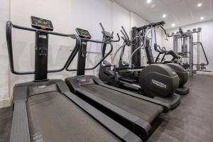 a gym with several tread machines in a room at NeoMagna Madrid in Madrid