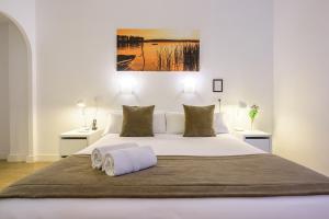 a bedroom with a large white bed with two tables at NeoMagna Madrid in Madrid