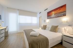 Habitación blanca con cama y escritorio en NeoMagna Madrid en Madrid