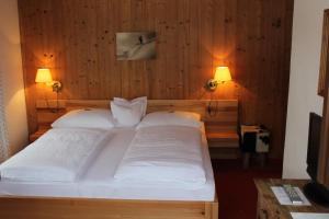 una camera da letto con un letto grande con due cuscini bianchi di Pension Feiersinger a Kitzbühel