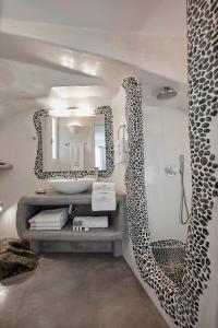 a bathroom with a sink and a mirror at Suites of the Gods Cave Spa Hotel in Megalokhori