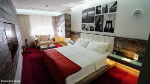 a bedroom with a large bed and a chair at Hayali Boutique Hotel in Erbil +14 photos