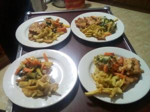 cuatro platos de comida en una bandeja en una mesa en Zagwe Hotel, en Lalibela