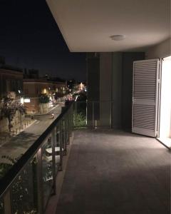 un balcon avec vue sur une rue la nuit dans l'établissement 3G BAROQUE APARTMENTS, à Lecce