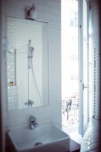 パリにあるホテル ムッシュー ヘルダーのバスルーム(洗面台、窓にシャワー付)