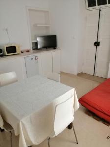 明德卢Casas do Cinema I的厨房配有白色桌子和红色沙发