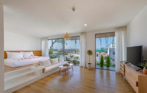 a living room with a large bed and a tv at Prana Boutique Hotel and Apartments in Da Nang