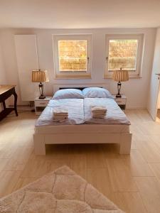 ein Schlafzimmer mit einem Bett mit zwei Fenstern und einem Klavier in der Unterkunft Souterrain Zimmer mit separatem Eingang und Bad in Düsseldorf