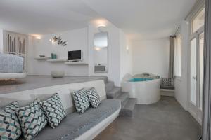 a living room with a couch and a tub at Suites of the Gods Cave Spa Hotel in Megalokhori