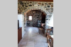 un arco en una cocina con una pared de piedra en Traditional stone house by the sea..., en Kapetanianá