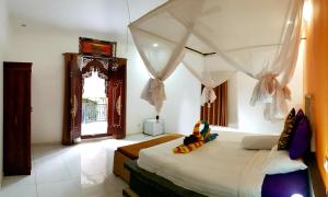 a bedroom with a large bed with a canopy at Amed Romance House in Amed