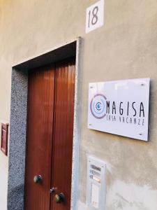a sign on the side of a building with a door at Casa Magisa in Noto