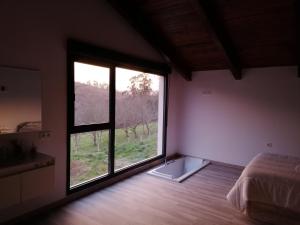 1 dormitorio con ventana grande con vistas a un campo en Casa pipete, en Siero