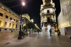 a city street at night with a clock tower w obiekcie Apartamento Suite Next to Catedral w Sewilli