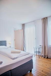 a bedroom with a bed and a table and windows at Gasthof Wastlwirt in Salzburg