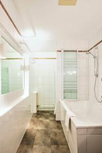 a white bathroom with a tub and a sink at Gasthof Wastlwirt in Salzburg