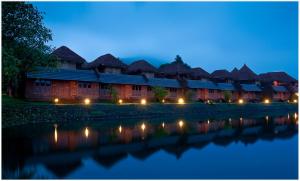 a row of lodges next to a river at night at SwaSwara Gokarna - a CGH Earth Experience in Gokarna