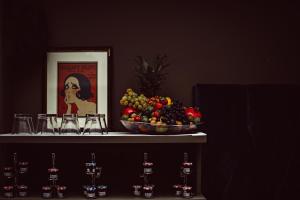 パリにあるムッシュ カデ ホテル ＆ スパのワイングラス付きのテーブルに盛られたフルーツボウル