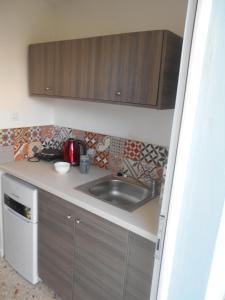 a kitchen with a sink and wooden cabinets at Sea Sight in Alykes
