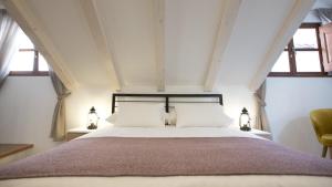 a bedroom with a large white bed with two windows at Villa Four Winds IV in Dubrovnik