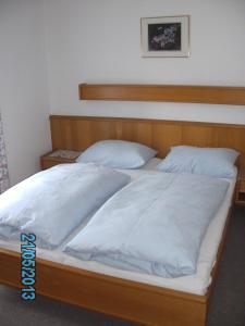 a large bed with white sheets and pillows at Haus Znopp in Saalbach Hinterglemm