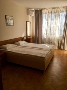 a bed in a bedroom with a large window at Sea Park Homes Neshkov in Varna City