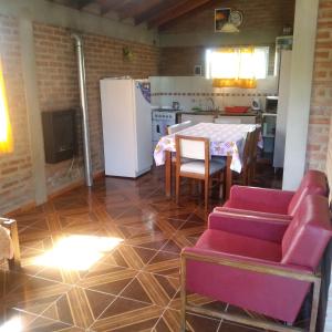 a living room with a table and a kitchen at Casa de Vero in Mina Clavero