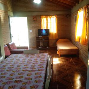 1 dormitorio con cama, sofá y TV en Casa de Vero en Mina Clavero
