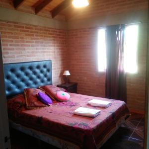 a bedroom with a bed with a blue headboard and pillows at Casa de Vero in Mina Clavero