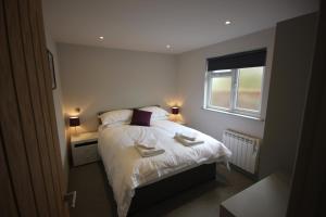 ein kleines Schlafzimmer mit einem Bett und einem Fenster in der Unterkunft Flintstone Cottages in Chichester