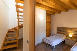 a bedroom with a bed and a wooden staircase at Ap. Artù - Lago di Garda in Tremosine Sul Garda