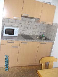 a small kitchen with a sink and a microwave at Haus Znopp in Saalbach Hinterglemm