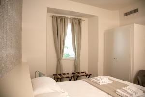 um quarto branco com uma cama e uma janela em Pietrapiana Boutique Apartments em Florença