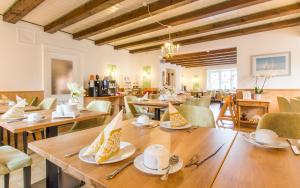 comedor con mesas y sillas de madera en Hotel Berlin Tegernsee en Rottach-Egern