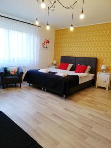 a bedroom with a large bed with red pillows at 7th Room Guest House in Oświęcim