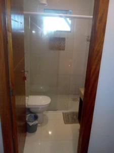 a bathroom with a toilet and a glass shower at Pousada do Maninho in Penha