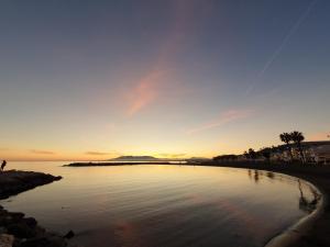 a body of water with the sunset in the background at El Nogal Home in Málaga